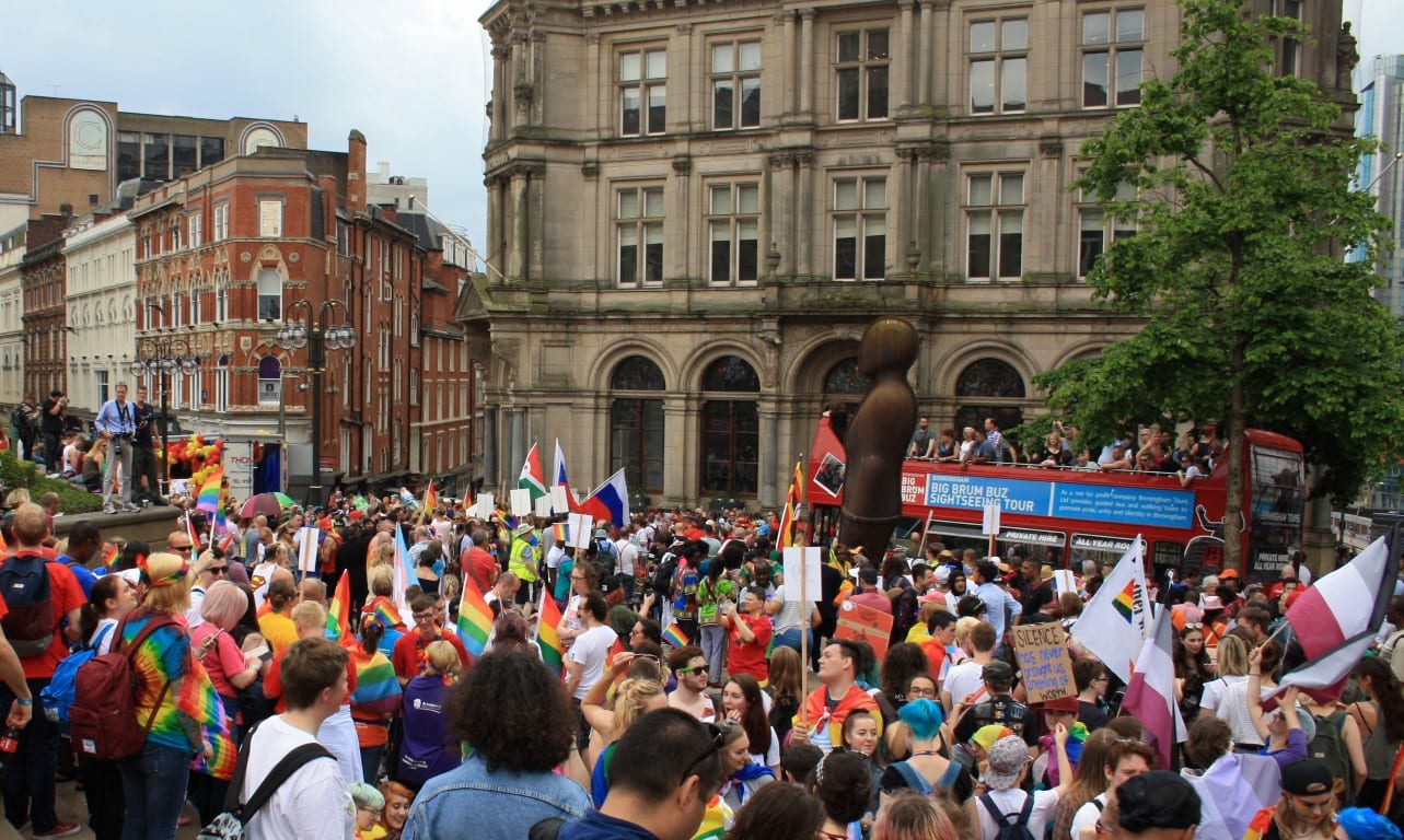 Birmingham Pride crowd walking holding pride flags Medium
